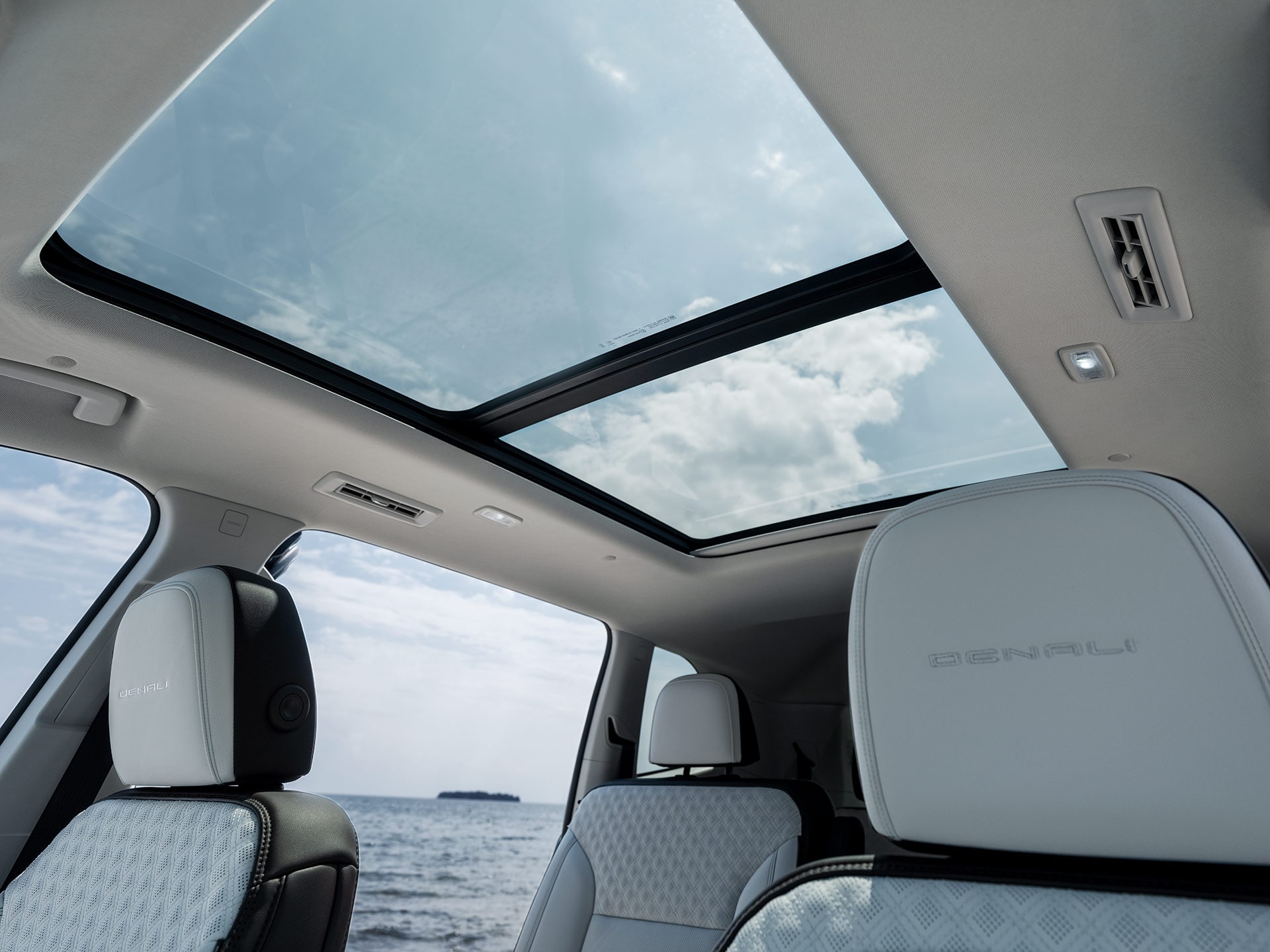 A Panoramic Sunroof in a GMC Vehicle from the Rear Seats with a View of the Ocean