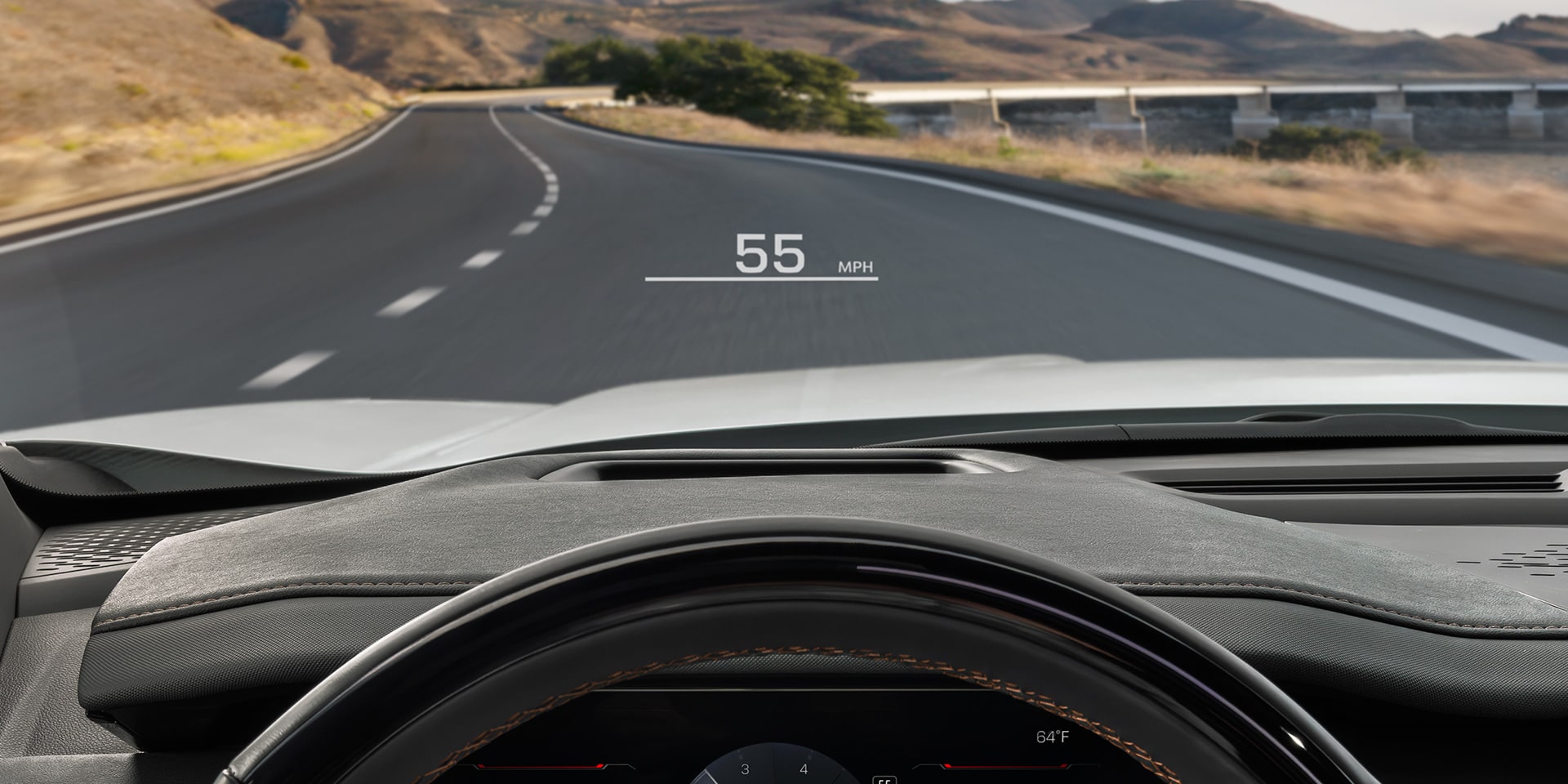 A Driver's Perspective Inside a GMC Vehicle, With Hands on The Steering Wheel, Showing The Digital Instrument Cluster and Road Ahead