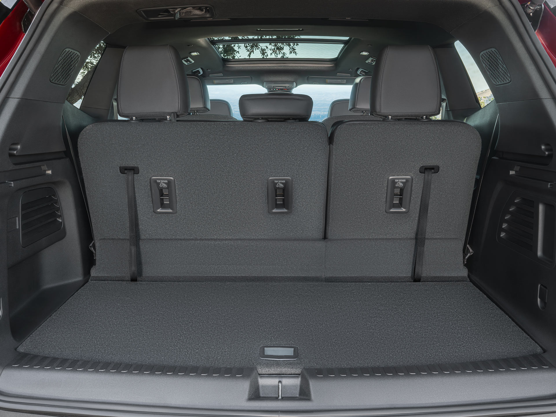 The Open Cargo Area Of a Red GMC SUV, Showing The Spacious Rear With Folded-Down Seats