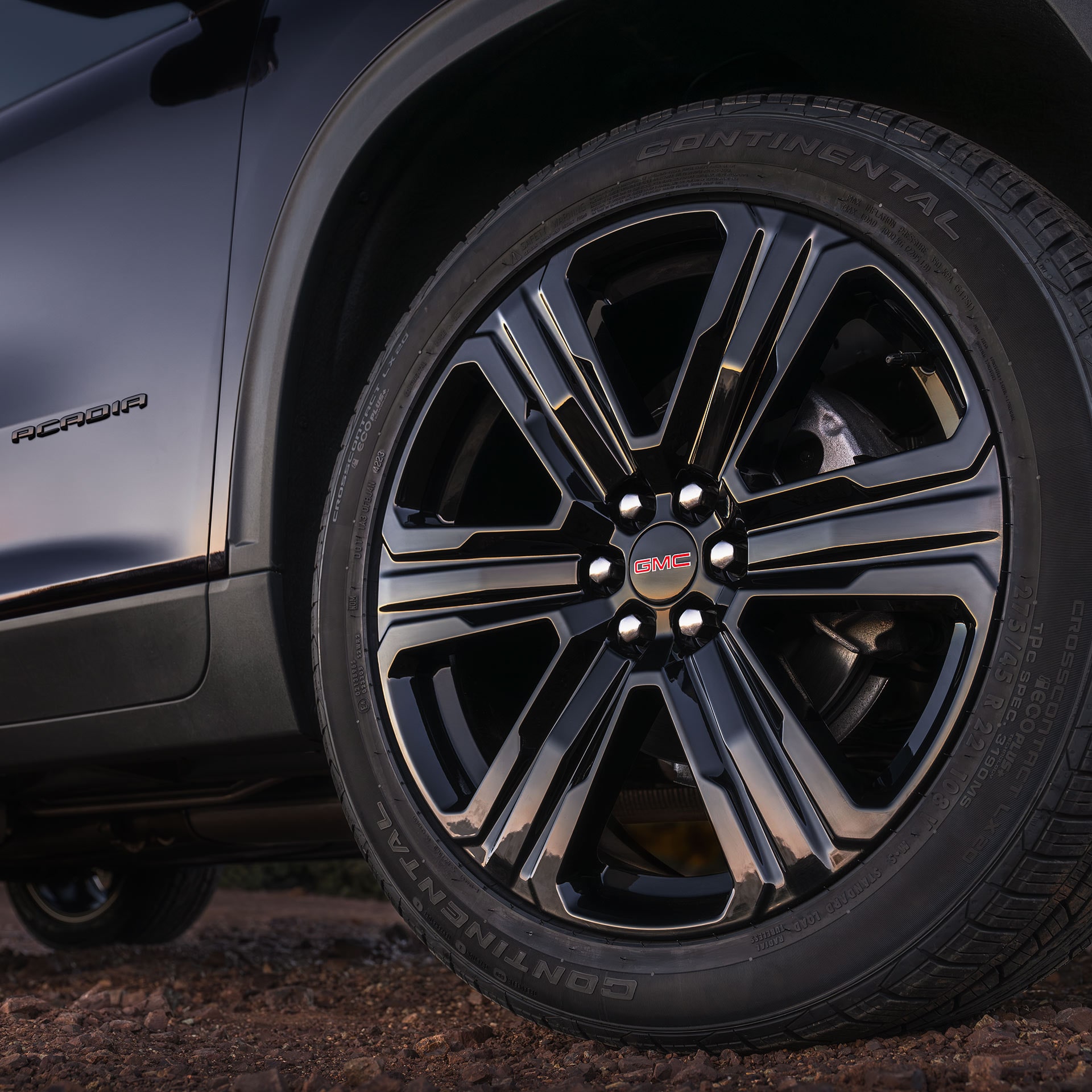 A Close-up of the GMC Acadia's Black Wheel with a Red GMC Logo and Continental Tires