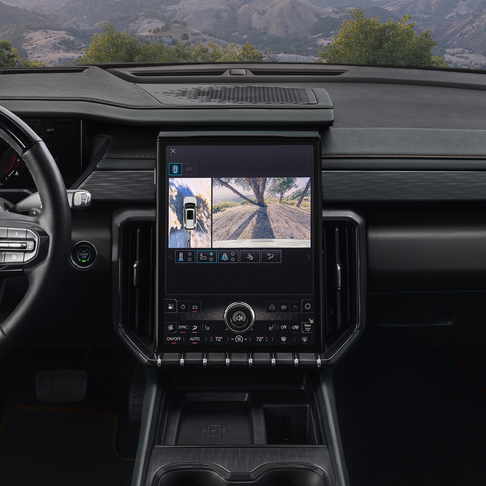 The Interior Dashboard of a GMC Vehicle Showing a Large Central Touchscreen Displaying a 360-Degree Camera View of a Rugged Landscape
