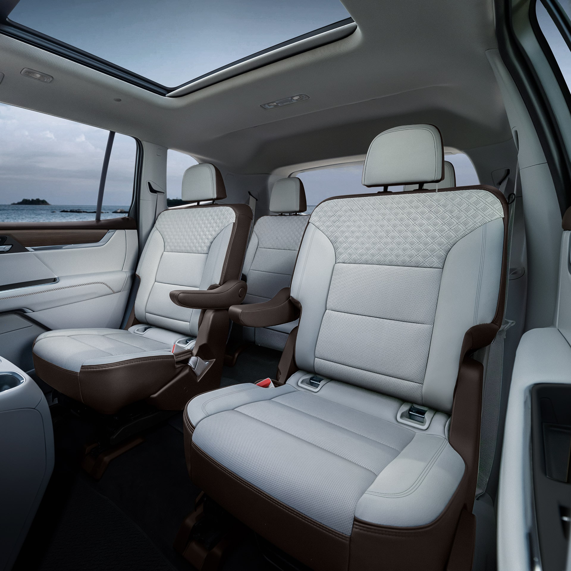 The Interior Rear Seats of a GMC Vehicle Showing White and Brown Leather Seats with Patterned Inserts and a Panoramic Sunroof