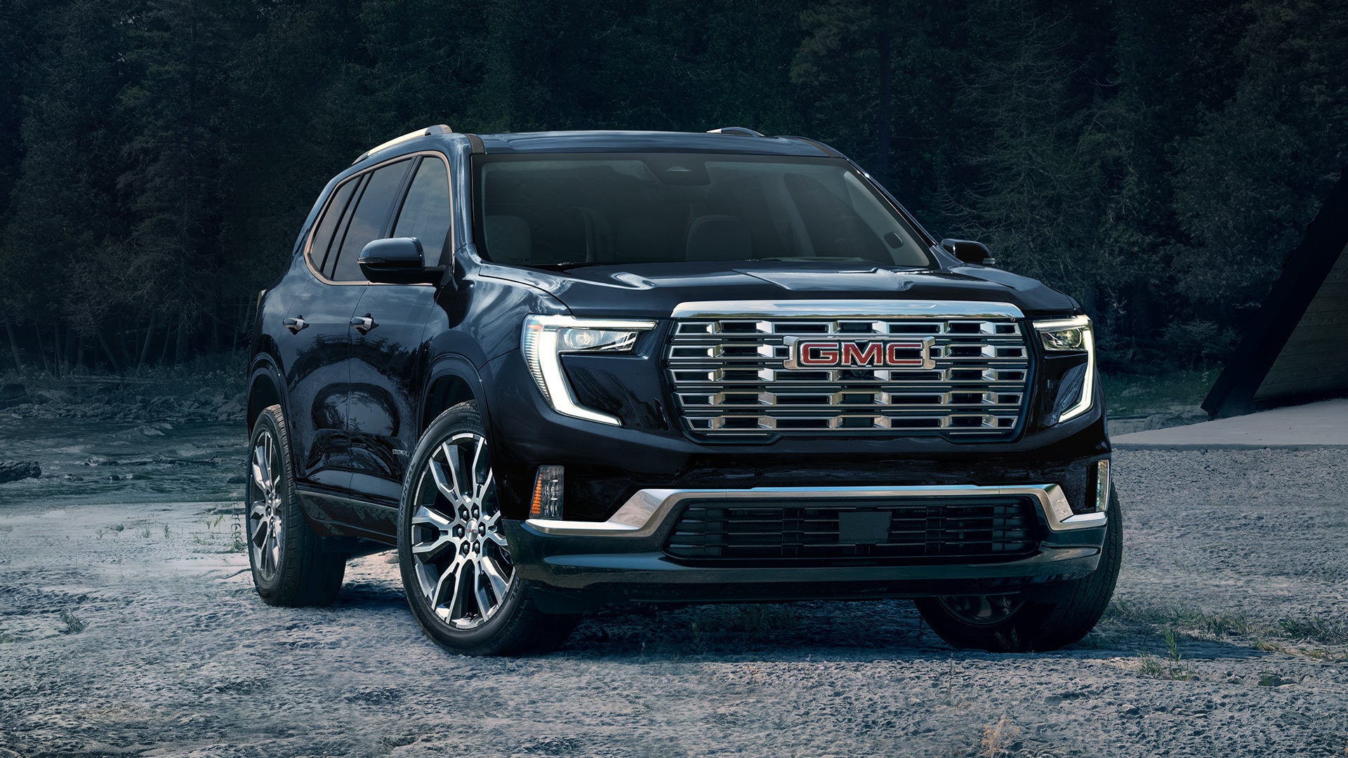 Front View of a GMC Acadia Parked on a Gravel Road.