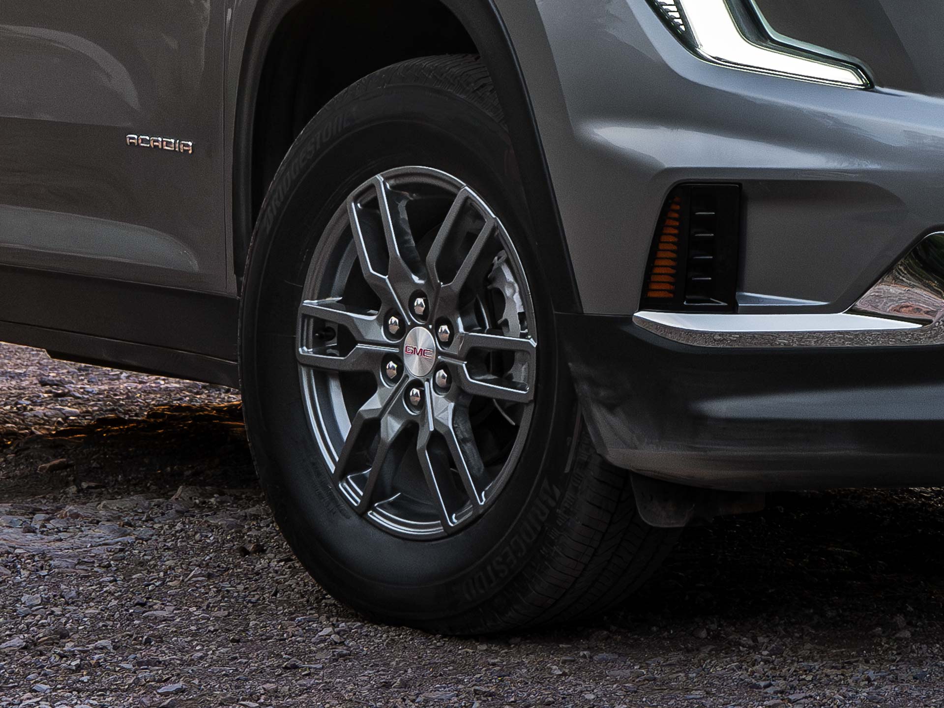 Close-up of the Front Lower Section And a Gray Multi-Spoke Wheel of a Gray GMC SUV