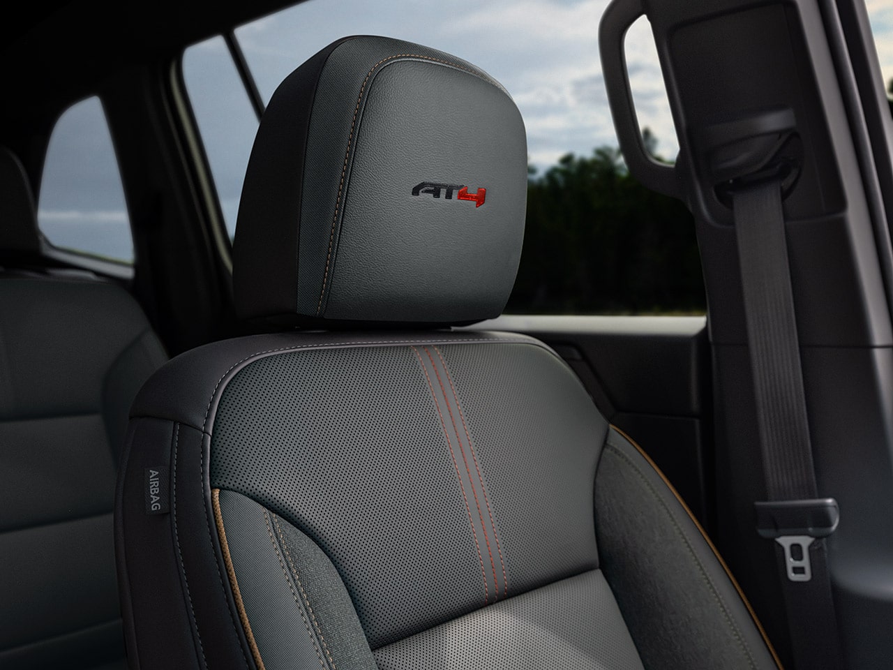 The Interior of a GMC AT4 Vehicle Featuring a Gray Leather Seat with an AT4 Logo on the Headrest
