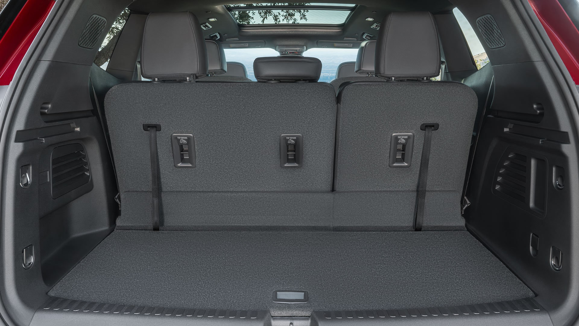 The Open Cargo Area of a Red GMC SUV, Showing The Spacious Rear With Folded-Down Seats