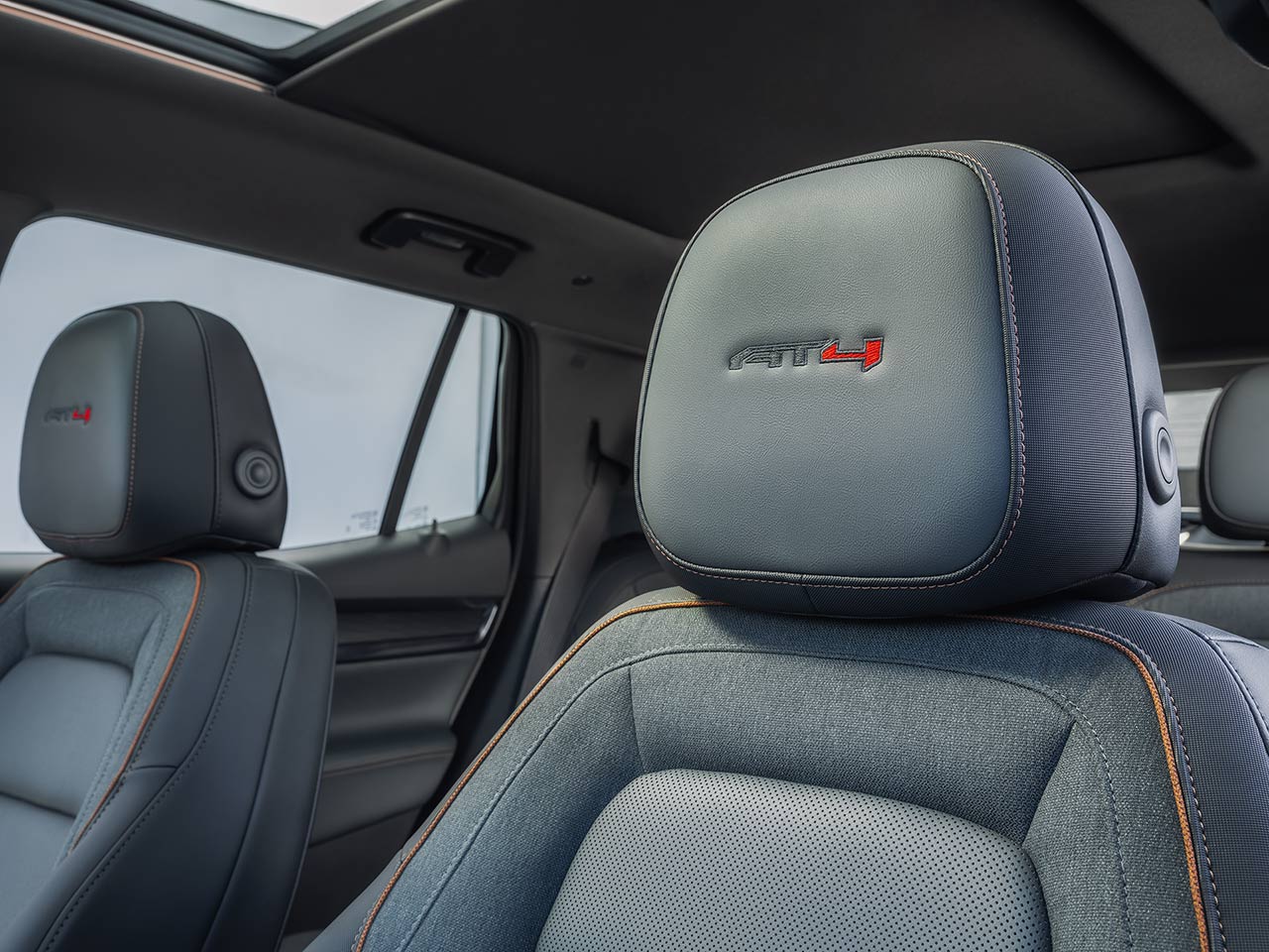 GMC Interior Headrests with Gray Upholstery and Orange Stitching Featuring the Red AT4 Logo on the Driver's Headrest