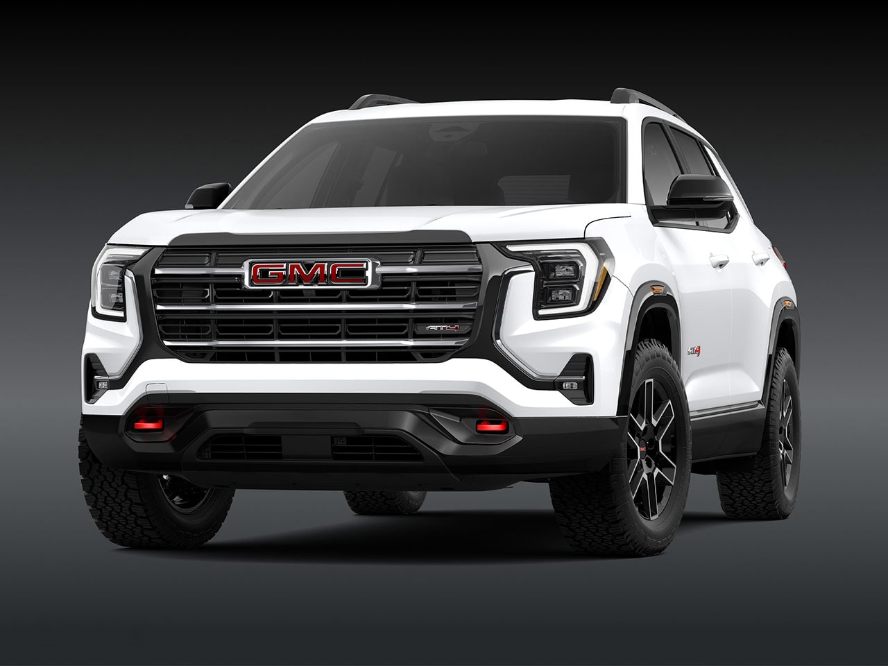 A Front Exterior View of a Pristine White GMC AT4 SUV with a Prominent Grille Headlights and Rugged Tires