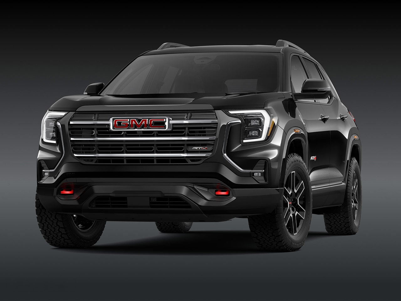 A Front Exterior View of a Sleek Black GMC AT4 SUV with a Prominent Grille Headlights and Rugged Tires