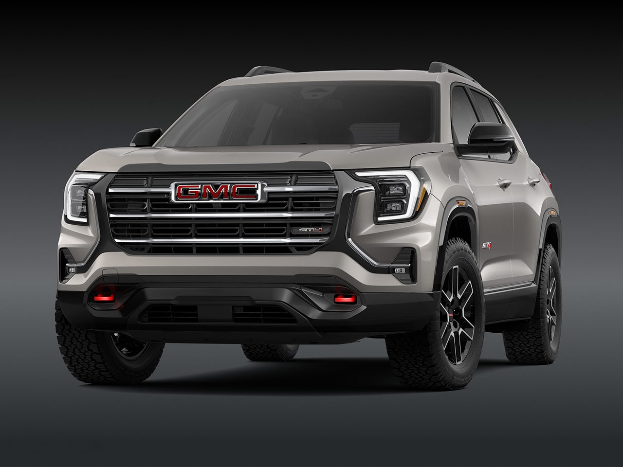 A Front Exterior View of a Light Brown GMC AT4 SUV with a Prominent Grille Headlights and Rugged Tires
