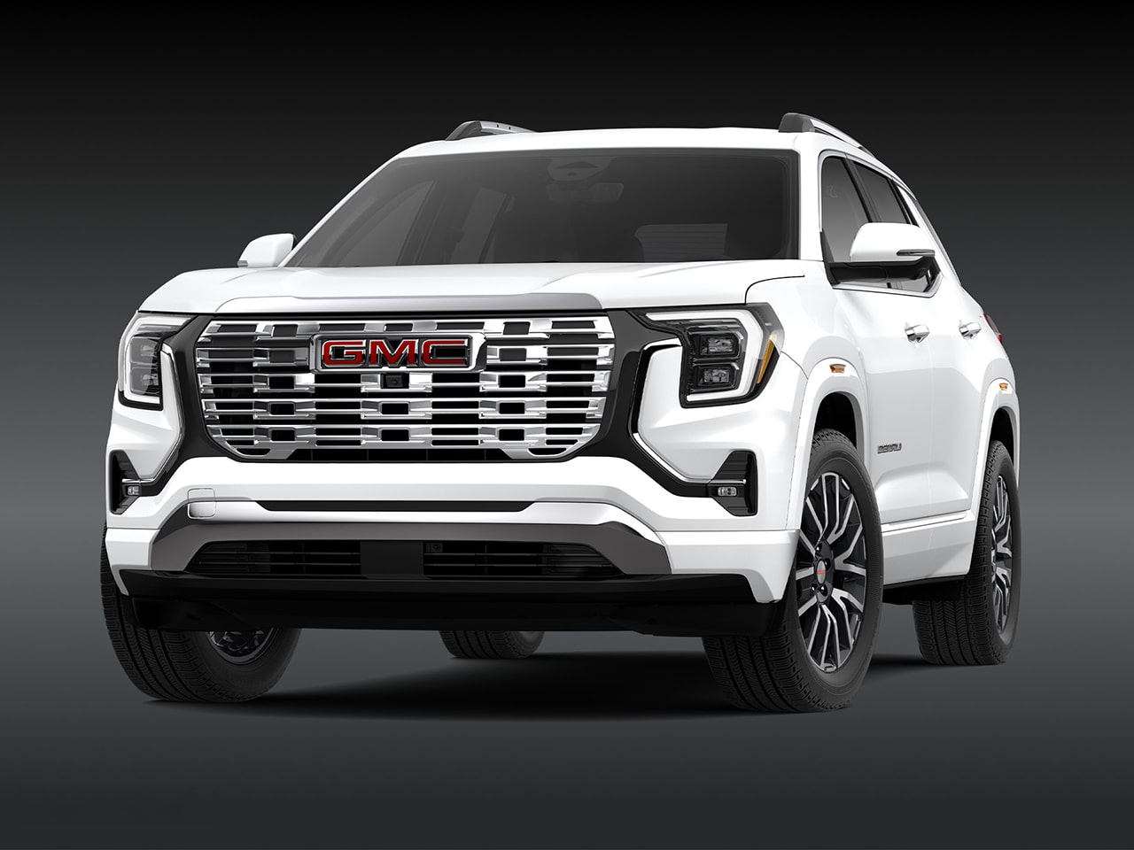 A Front Three-Quarter View of the White 2026 GMC Denali SUV on a Dark Background