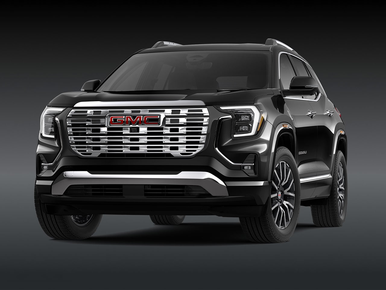 A Front Three-Quarter View of the Black 2026 GMC Denali SUV on a Dark Background