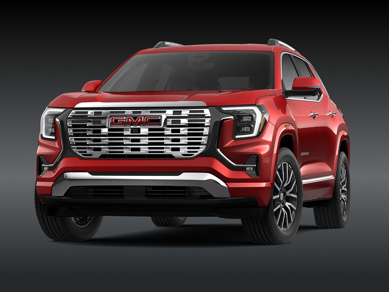 A Front Three-Quarter View of the Red 2026 GMC Denali SUV on a Dark Background