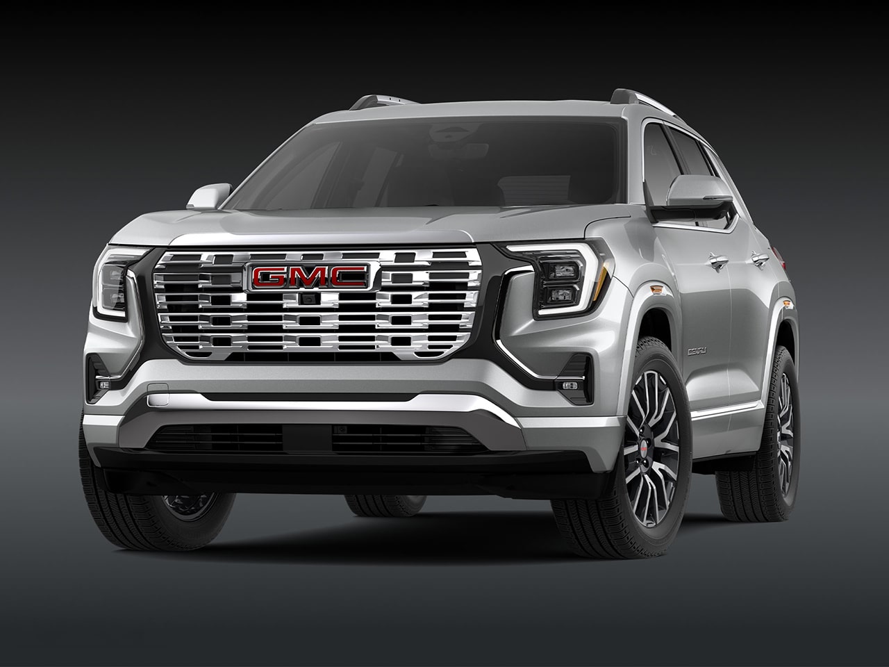 A Front Three-Quarter View of the Silver 2026 GMC Denali SUV on a Dark Background