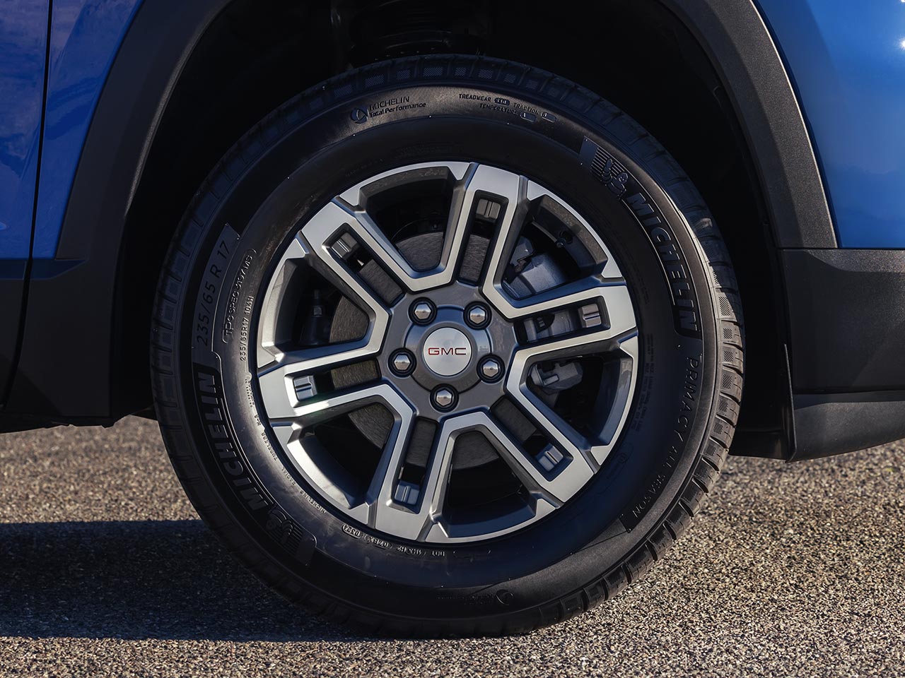 Blue GMC Terrain SUV with a Silver and Black Wheel in the Foreground