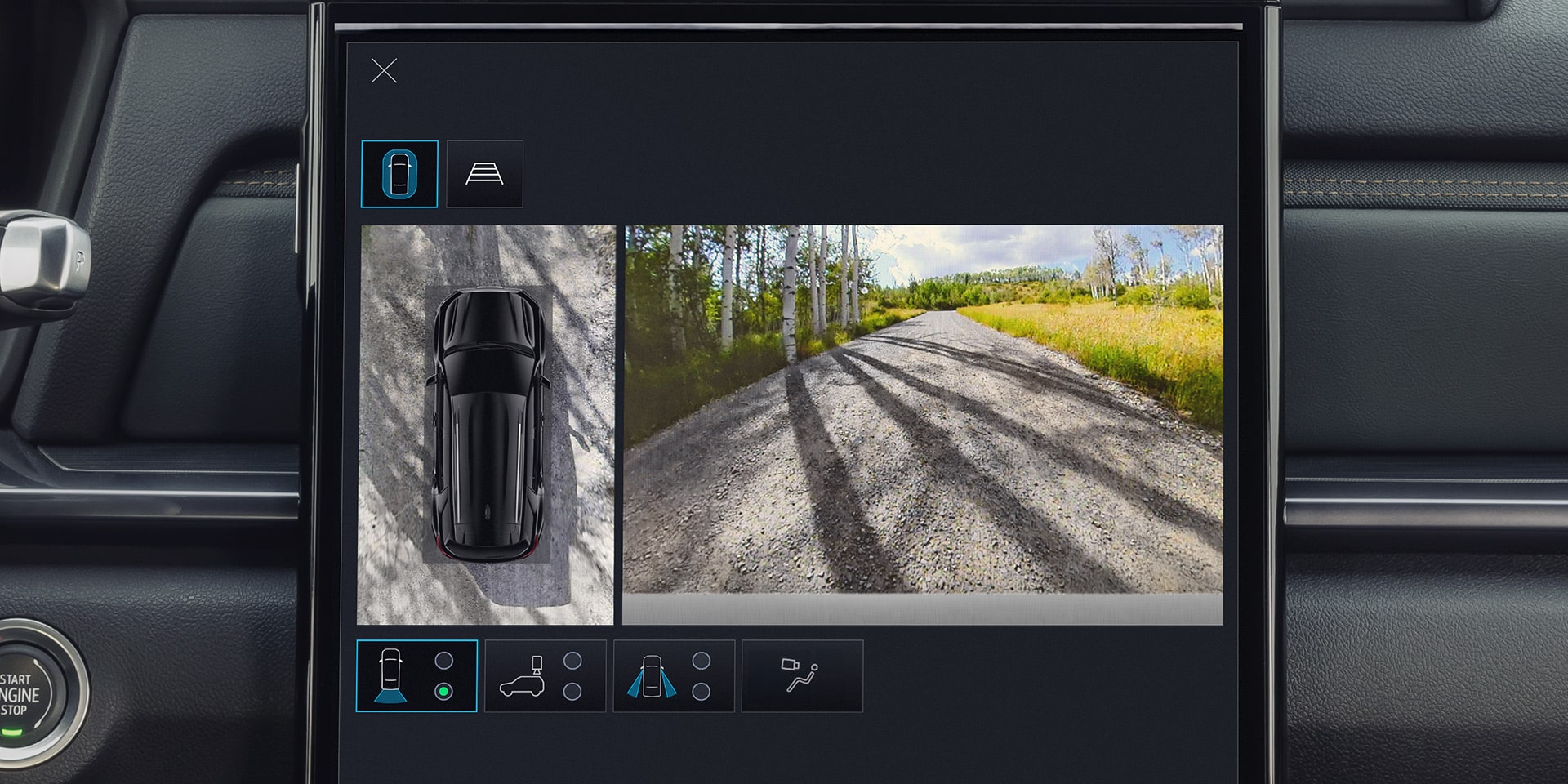 A GMC Vehicle's Multi-camera View Showing a Black SUV From Above on the Left and a Gravel Road Through a Birch Tree Forest on the Right
