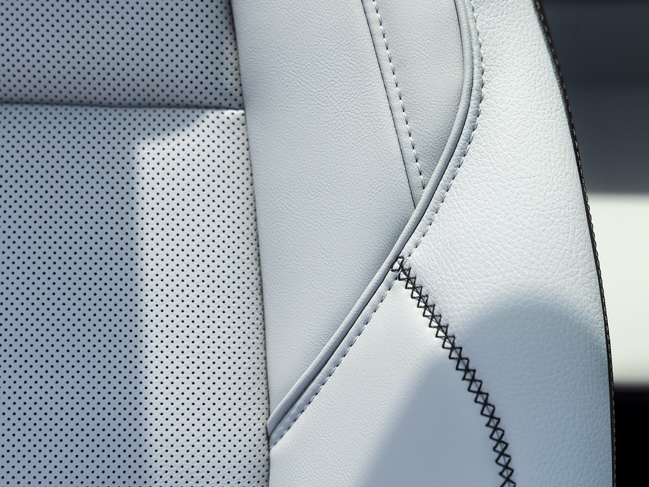 Close-Up of a White Perforated Leather Car Seat with Detailed Stitching