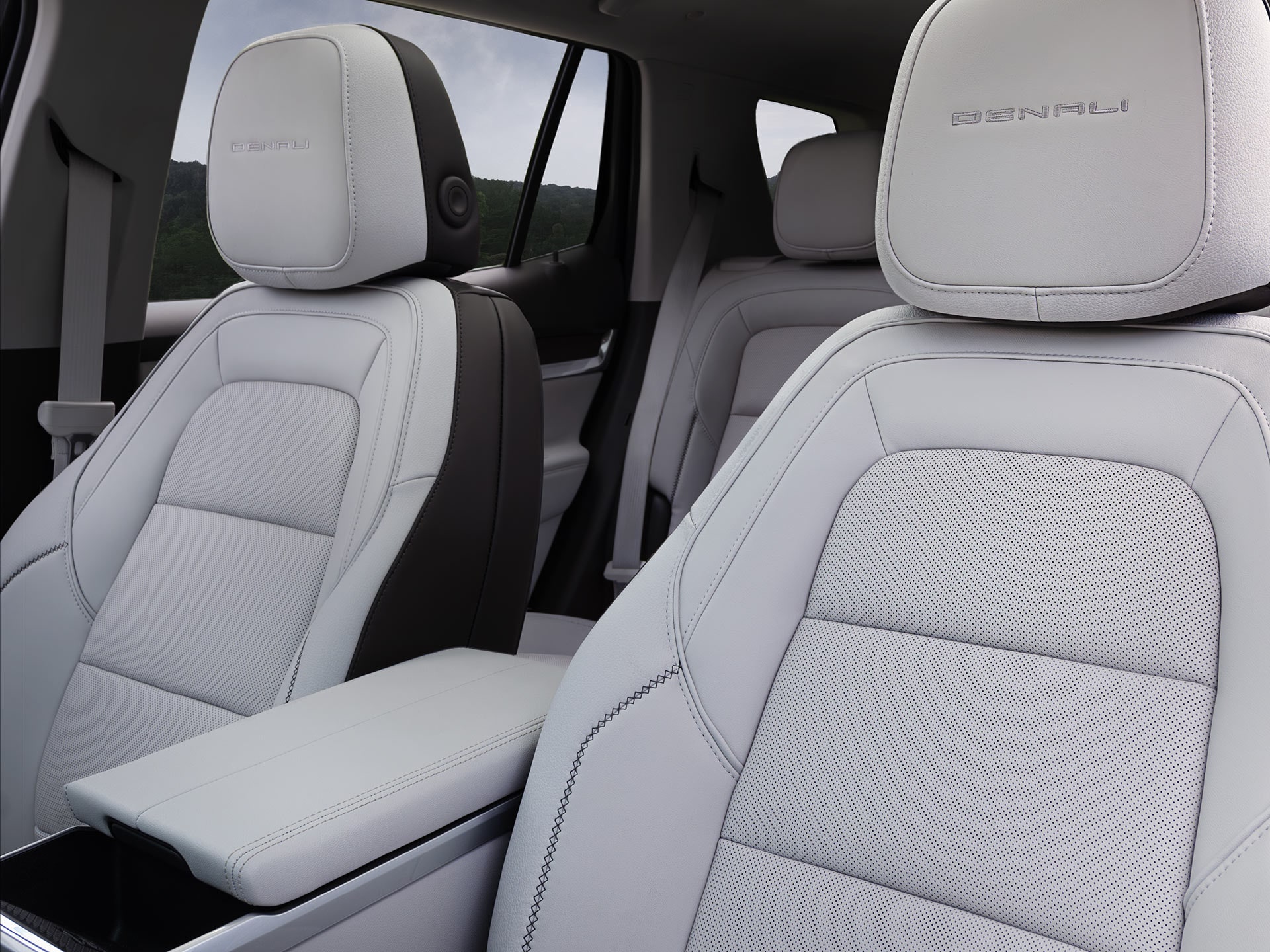 An Interior View of a GMC Denali SUV Showing the Front Gray Leather Seats with Denali Embossed on the Headrests