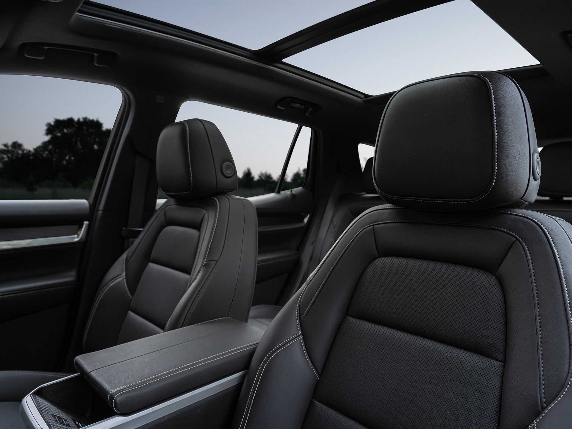 GMC Interior Featuring Dark Gray Leather Front Seats with White Stitching and a Panoramic Sunroof