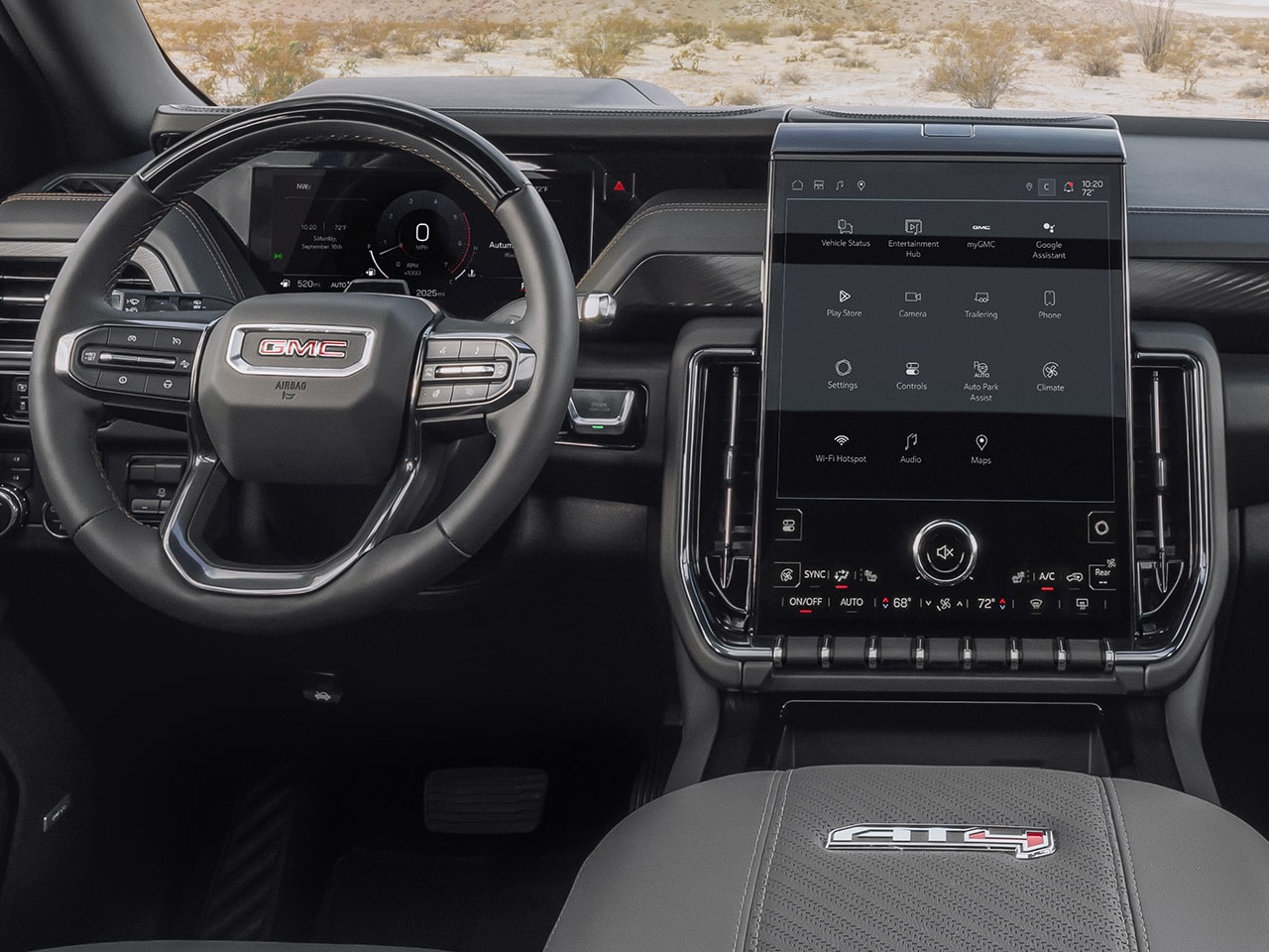 Wide Interior View of the 2027 GMC Yukon Front Cabin Showing Steering Wheel Touchscreen and an AT4X Badge