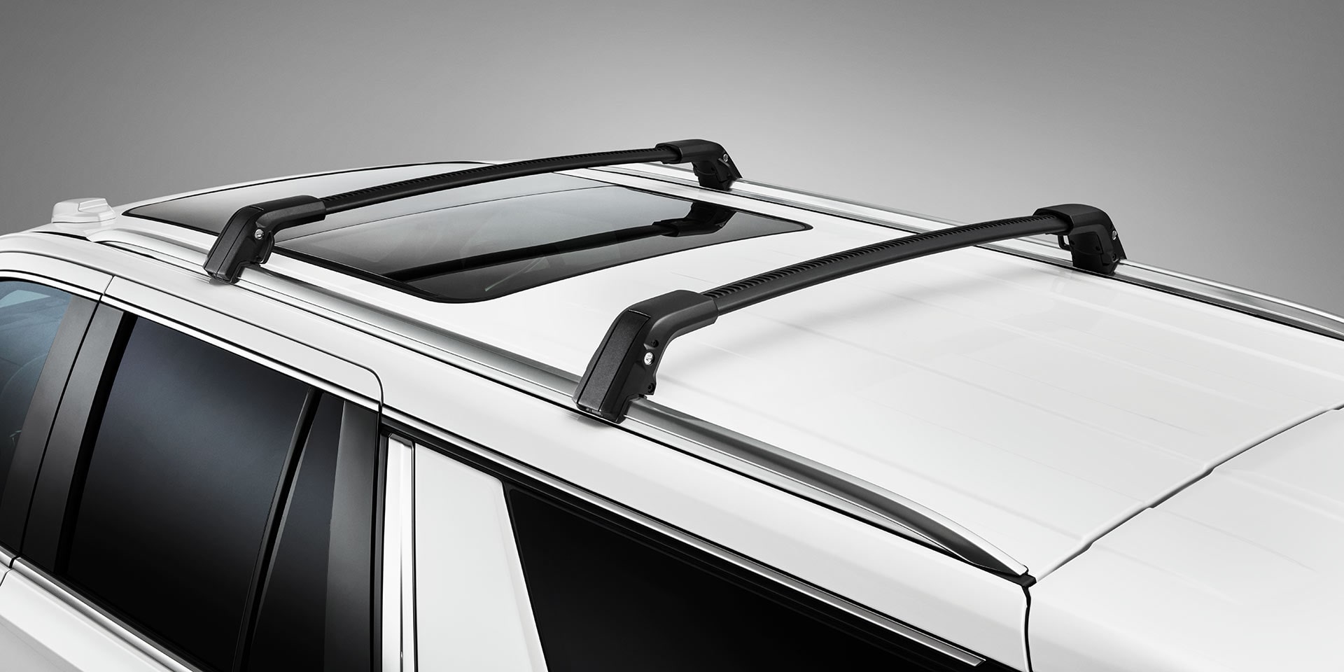 A White GMC Yukon with Black Crossbars for Exterior Cargo Management