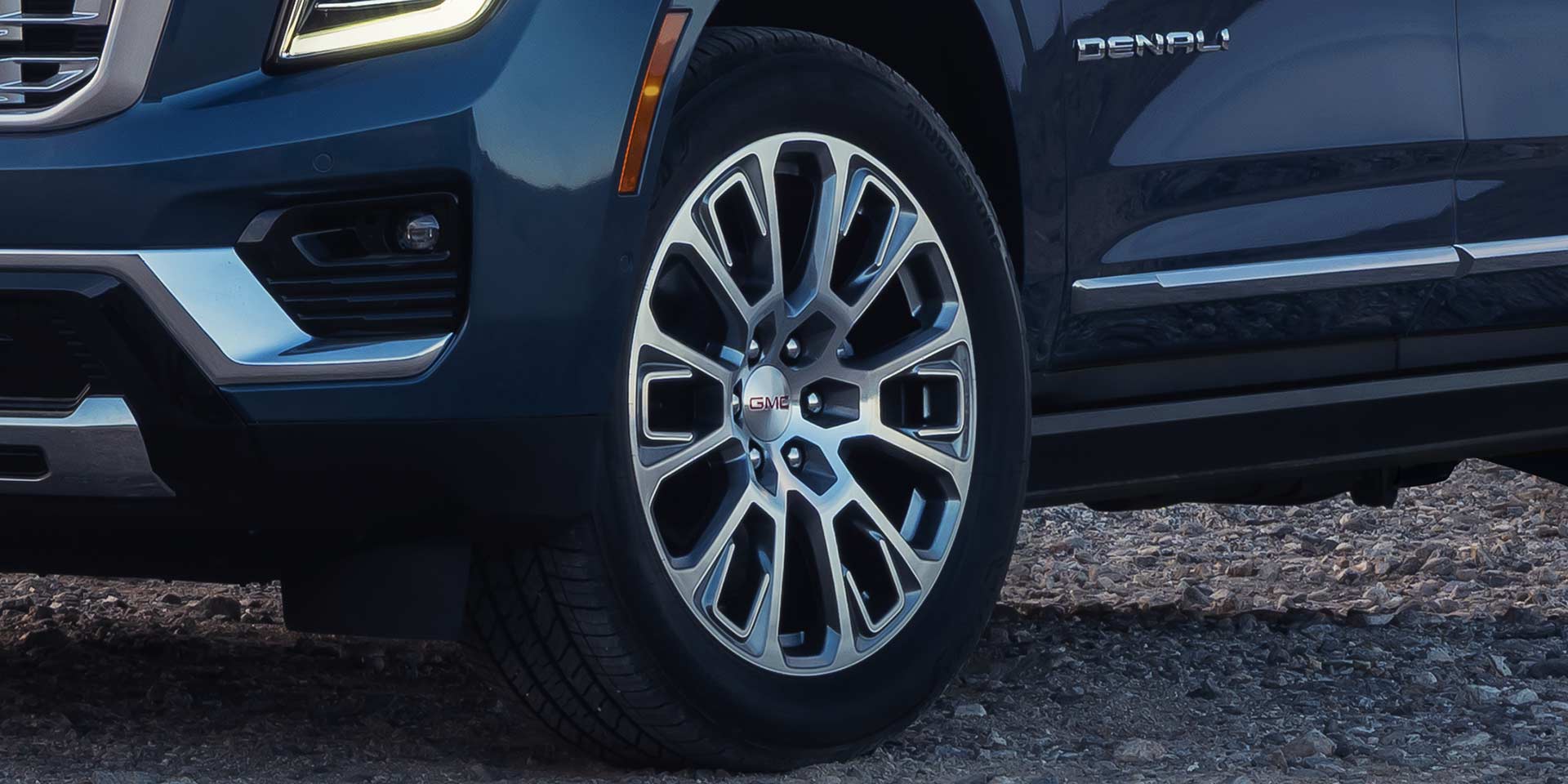 Close-Up of a Dark-Colored 2027 GMC Yukon's Intricate Silver and Black Multi-Spoke Wheel Design