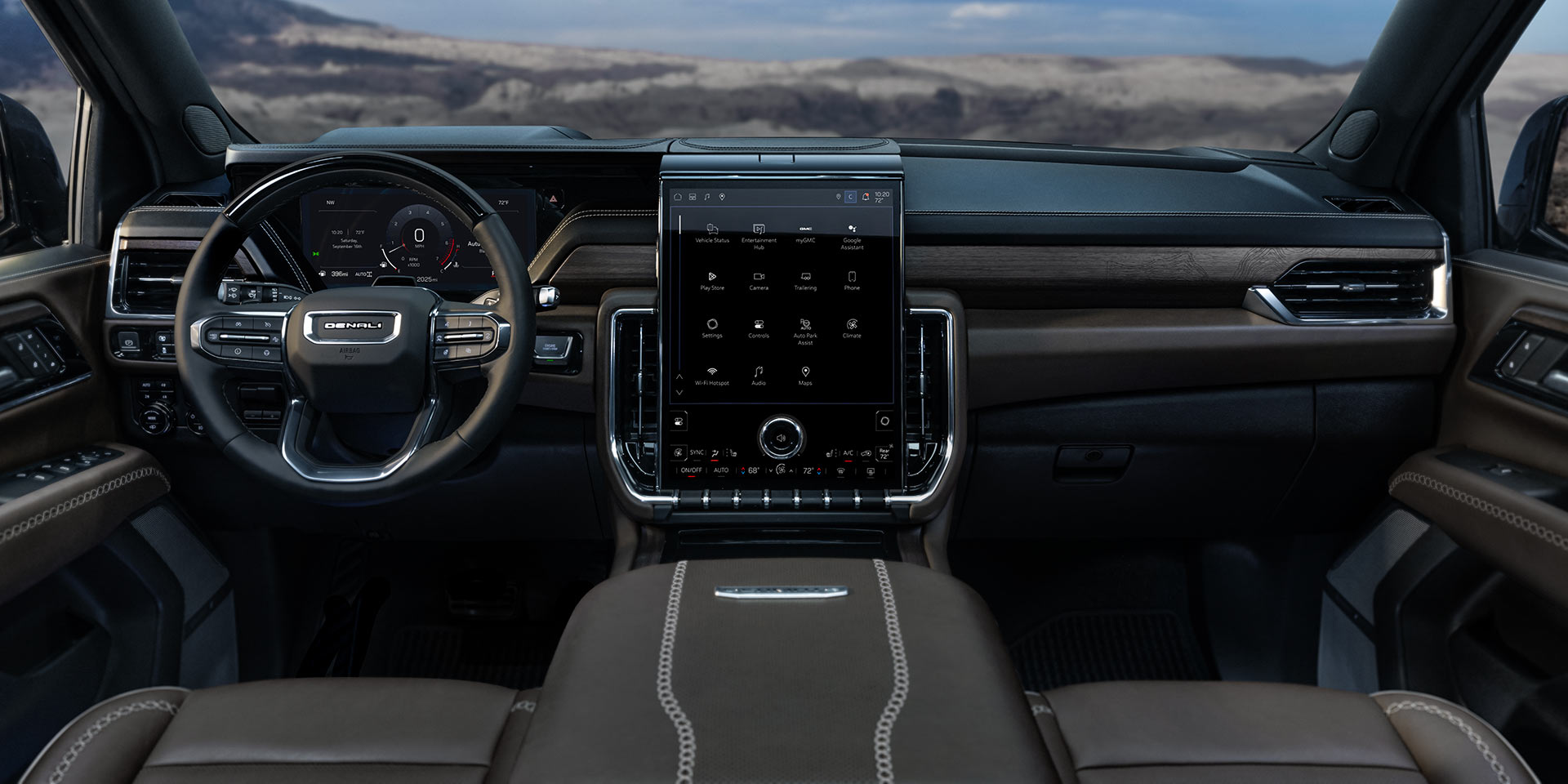 Wide Interior View of the 2027 GMC Yukon Denali Dashboard with a Steering Wheel and Large Infotainment Screen Against a Mountain Backdrop