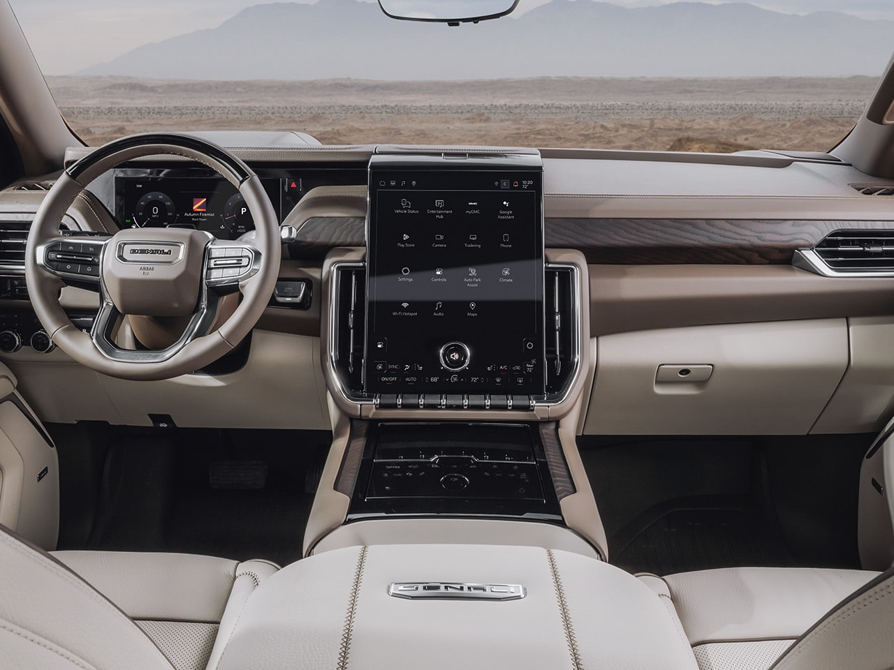 Wide Interior View of the 2027 GMC Yukon Denali Ultimate Dashboard Featuring Light Beige and Brown Trim, a Large Infotainment Screen, and Ultimate Badging