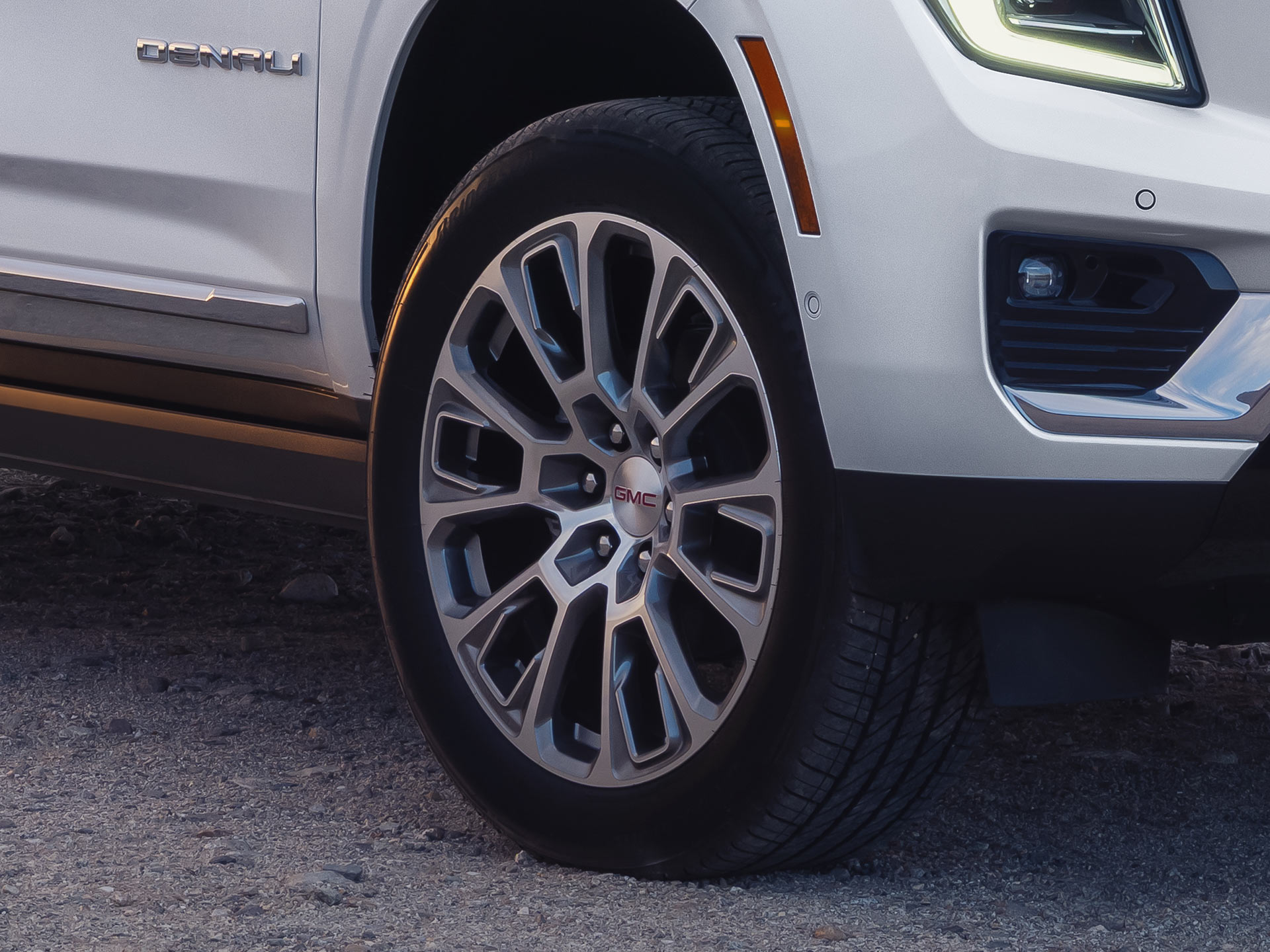 Close-Up of a White 2027 GMC Yukon's Intricate Silver and Black Multi-Spoke Wheel Design with the GMC Logo