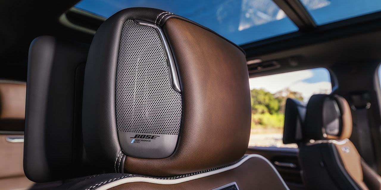 Close-up of a Bose Performance Series Speaker Grille on a Black Leather Seat in the 2027 GMC Yukon