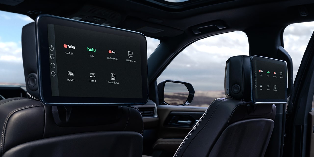 Rear Interior View of a GMC Yukon XL with Dual Seatback Media Screens Displaying Entertainment Options