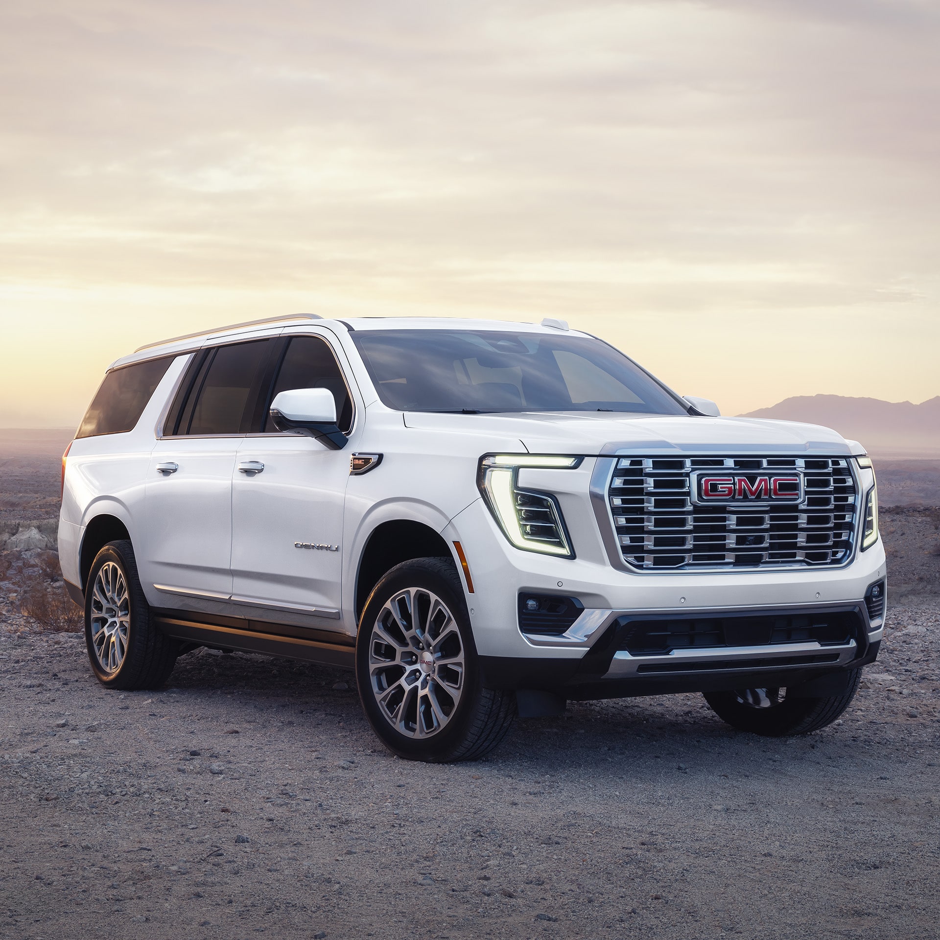 A White 2027 GMC Yukon XL Denali Parked on a Dirt Road in a Desert Landscape