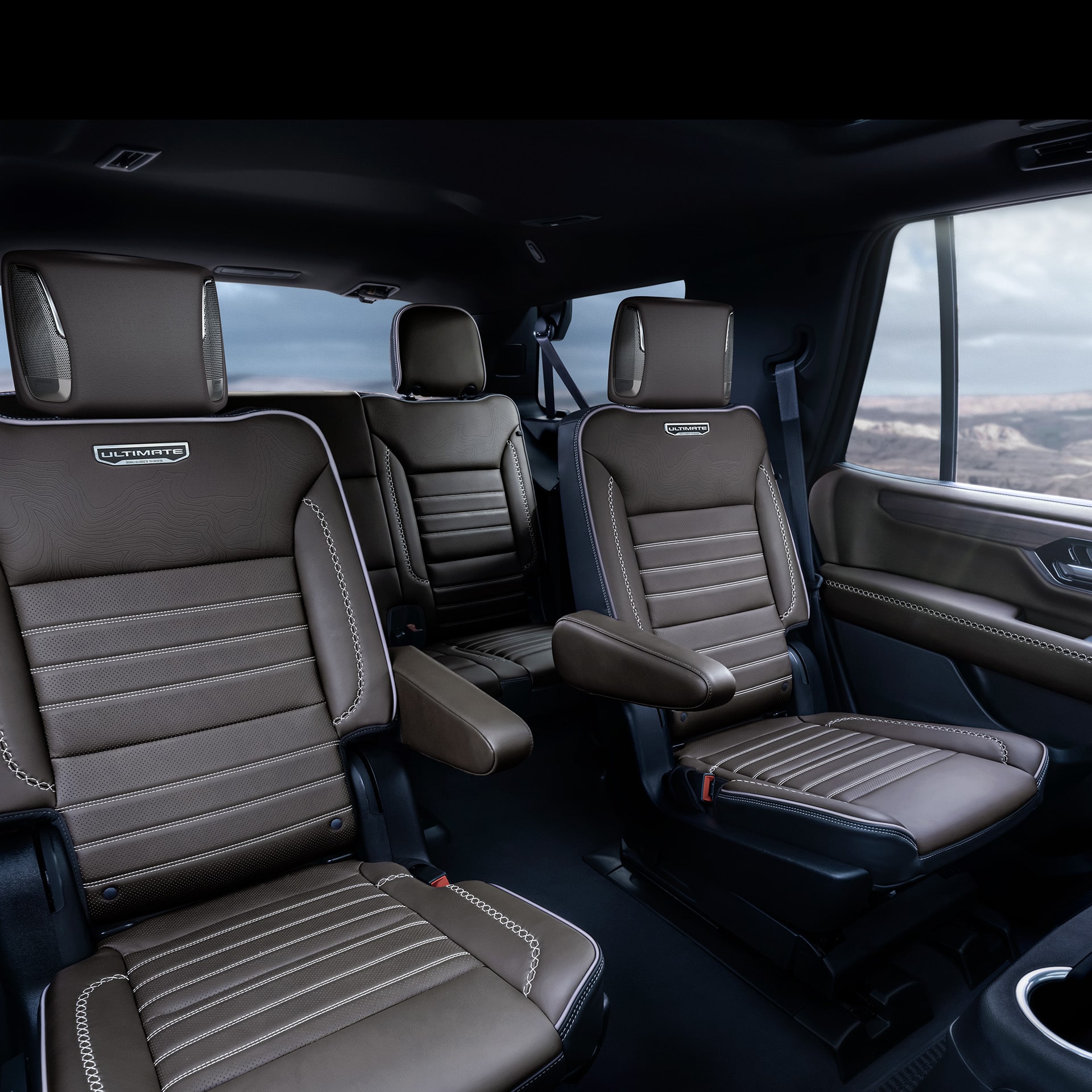 Rear Interior of a 2027 GMC Yukon Denali Ultimate with Brown Leather Seats and the Ultimate Emblem Visible