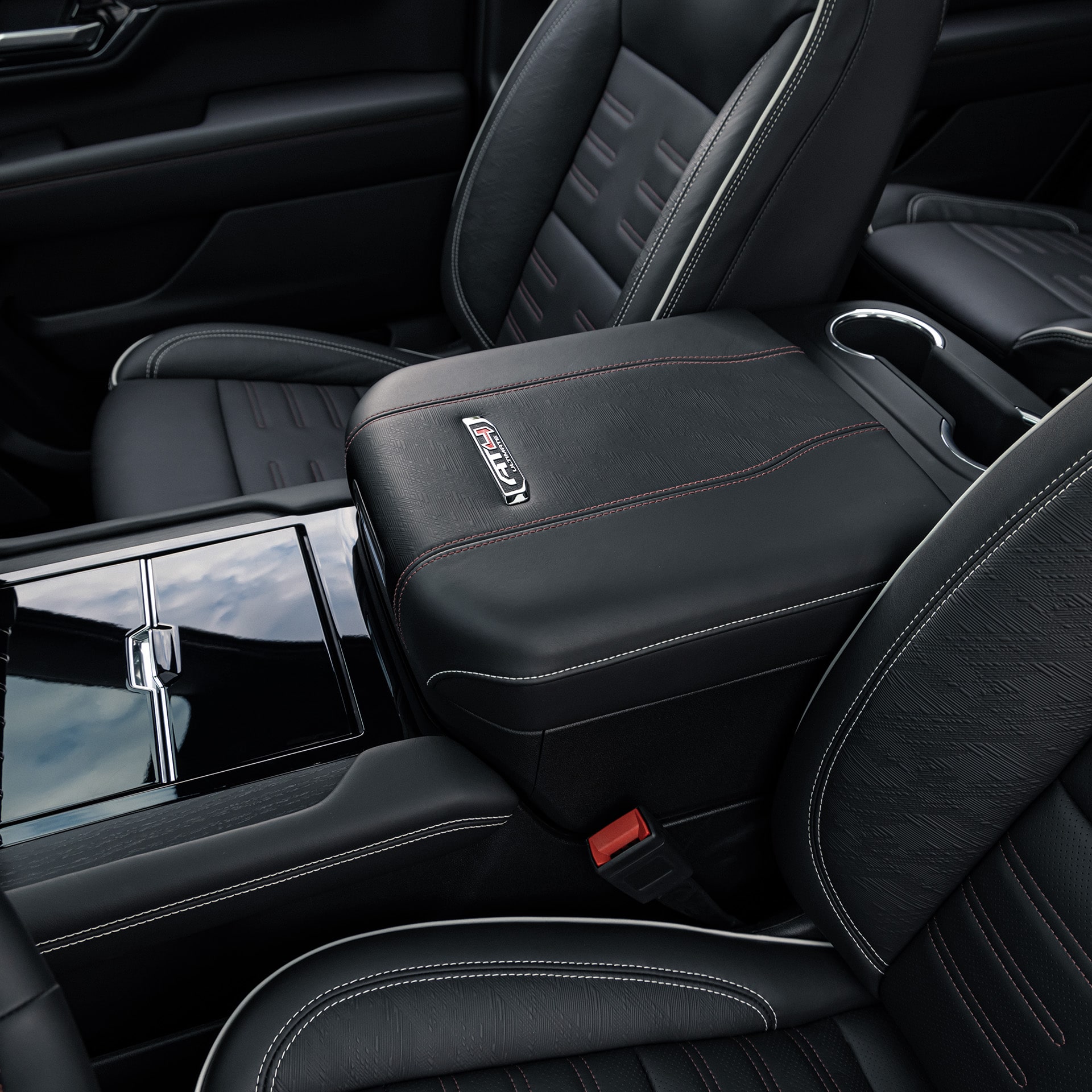 Close-up of the Black Leather Center Console with Red Stitching and Denali Emblem in a 2027 GMC Yukon Denali