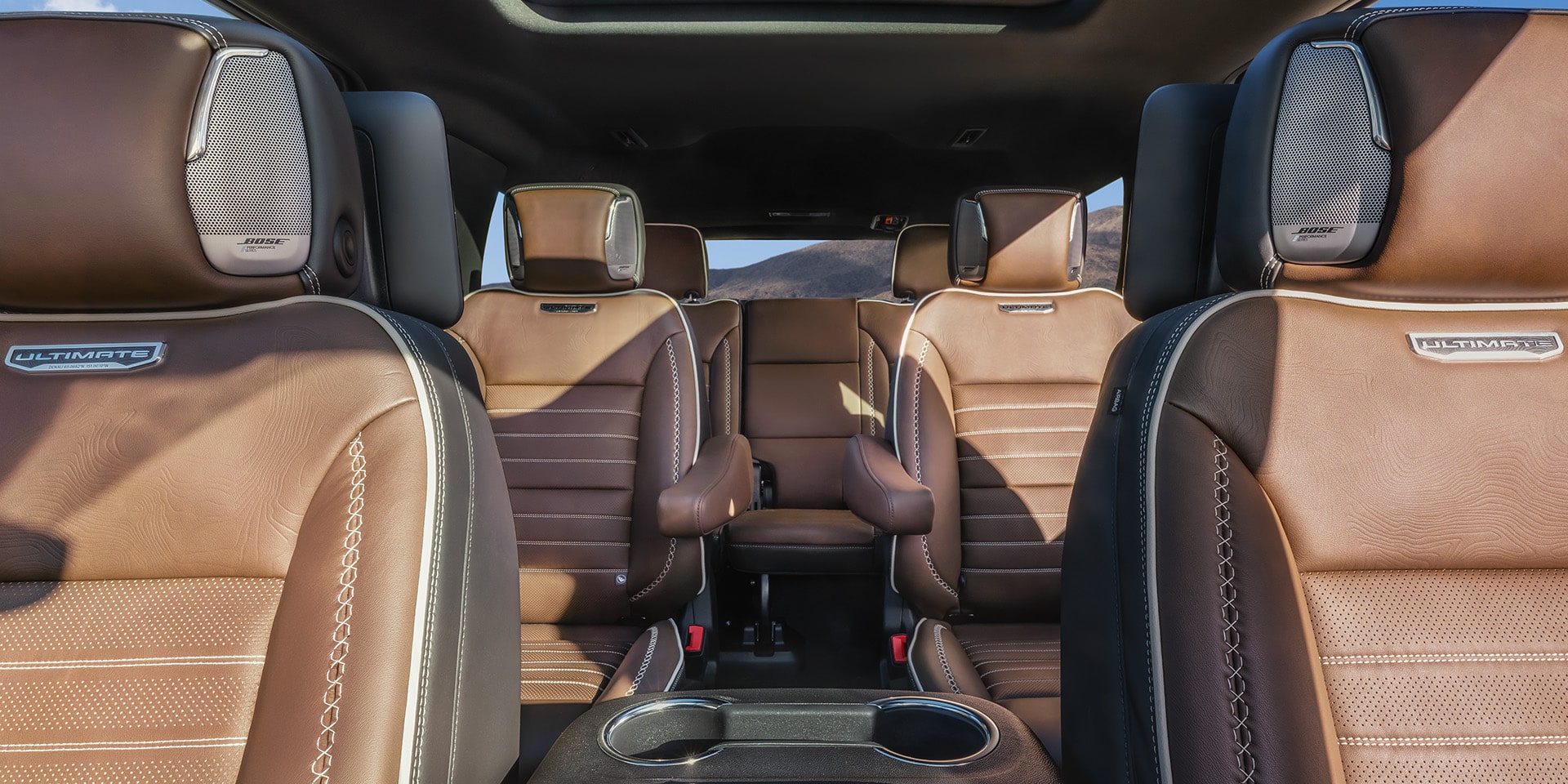 Interior View of Brown Leather Seats with Ultimate Badging and Bose Speakers in a 2027 GMC Yukon Denali Ultimate