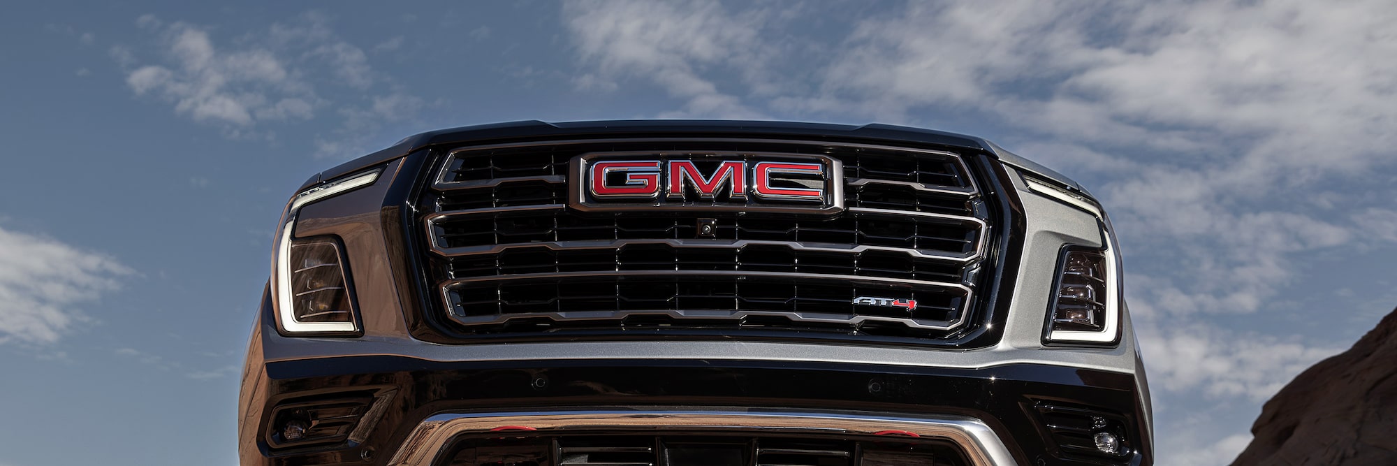 An Extreme Low-Angle View of a GMC Yukon AT4 with its Undercarriage and Red Recovery Hooks