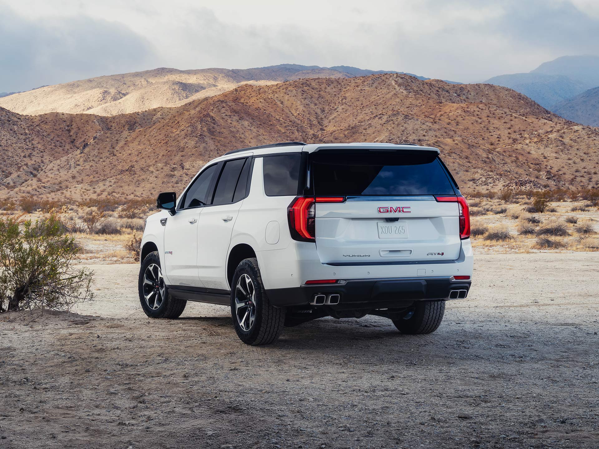 A White GMC Yukon AT4 Parked on a Dirt Road in a Desert Landscape