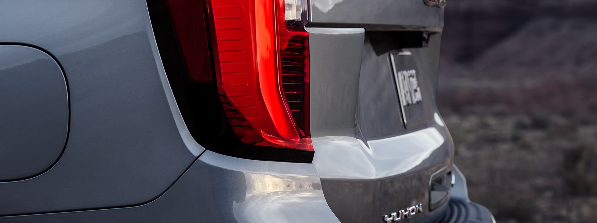 A Close-Up Rear View of a Silver GMC Yukon AT4 Taillight and License Plate