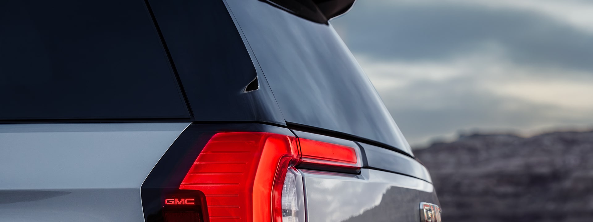 A Close-Up Rear View of a Silver GMC Yukon AT4 Taillight and License Plate