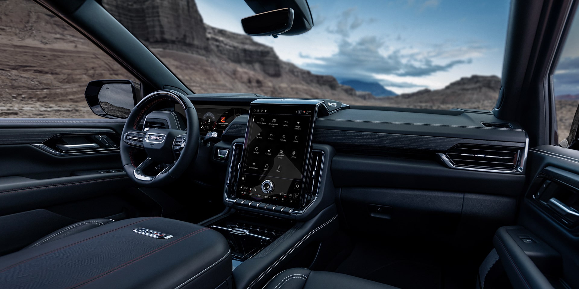 Front Interior Dashboard View of a GMC Yukon AT4 Ultimate with Dark Upholstery and a Large Infotainment Screen
