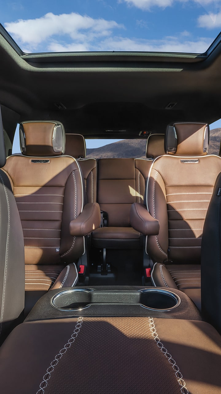 Interior View of GMC Yukon Denali Ultimate Second and Third Row Brown Leather Seats with Ultimate Branding