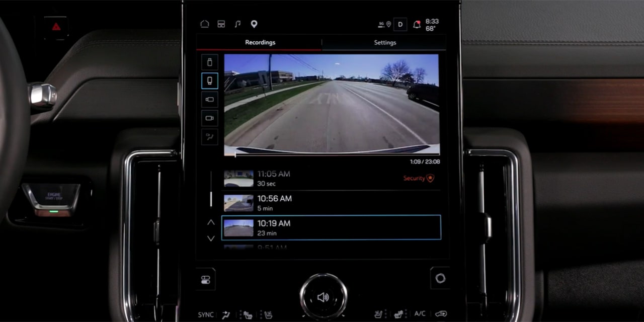 Central Infotainment Screen of a GMC Yukon XL Displaying Security Camera Recordings of a Parking Lot with Timestamps