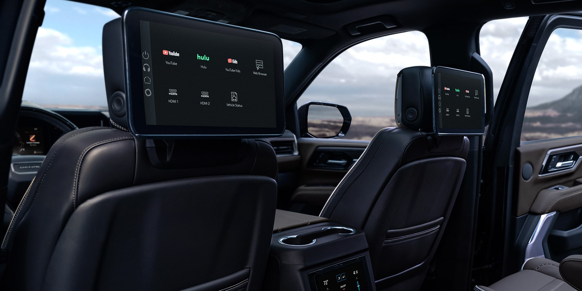 Rear Interior View of a GMC Yukon XL with Dual Seatback Media Screens Displaying Entertainment Options