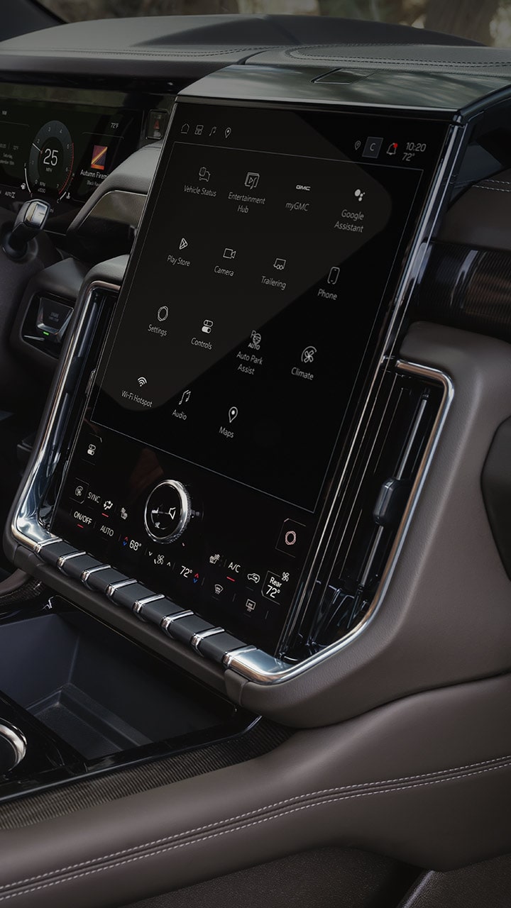 Interior View of a GMC Yukon XL Showing the Driver's Hand on the Steering Wheel and the Large Infotainment Screen