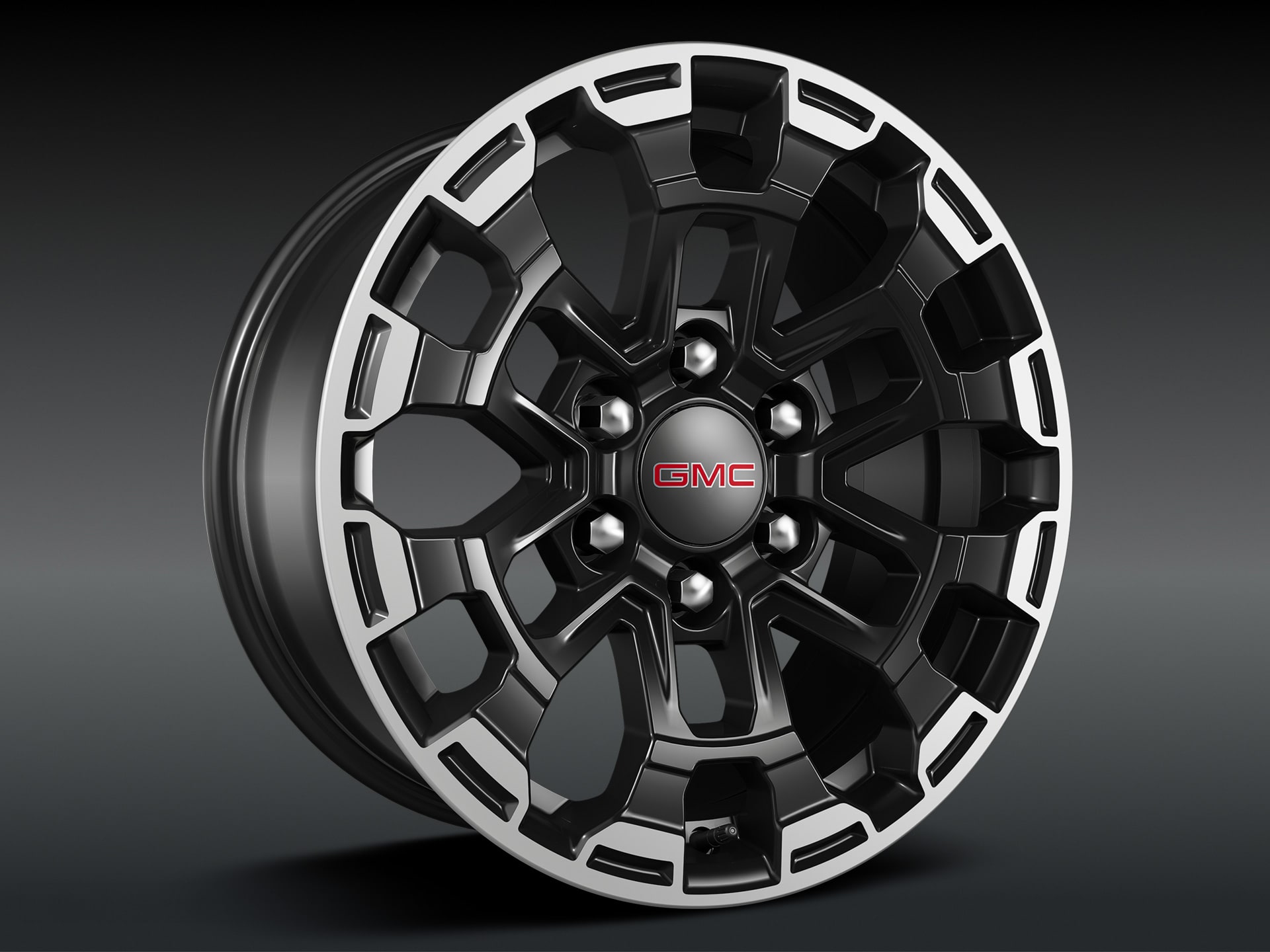 A Close-Up View of the Front Wheel and Tire of a 2027 GMC Canyon AT4X on a Rocky Trail