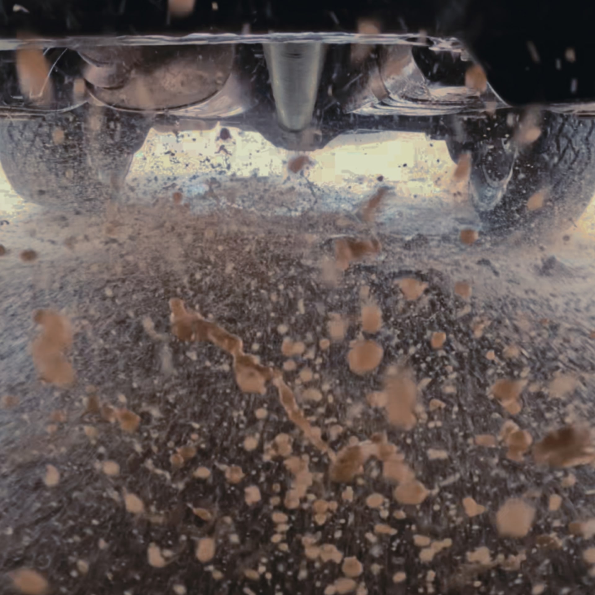 Mud and Water Splashing Up From Under a 2027 GMC Canyon as it Drives Off-Road