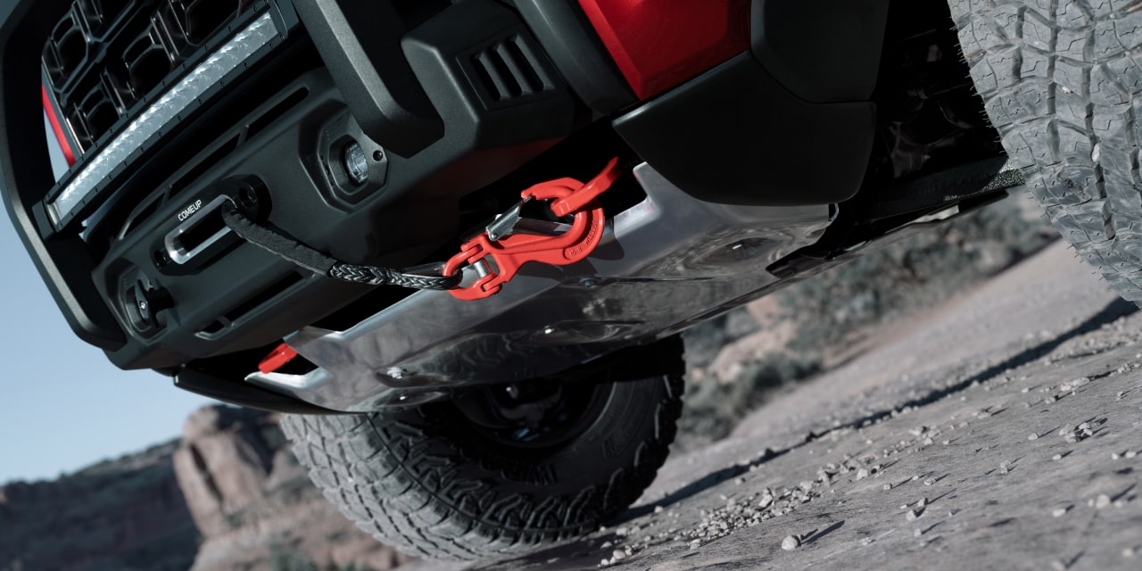 The Front Lower View of a Red 2027 GMC Canyon AT4X on a Rocky Trail with a Winch and Red Tow Hook