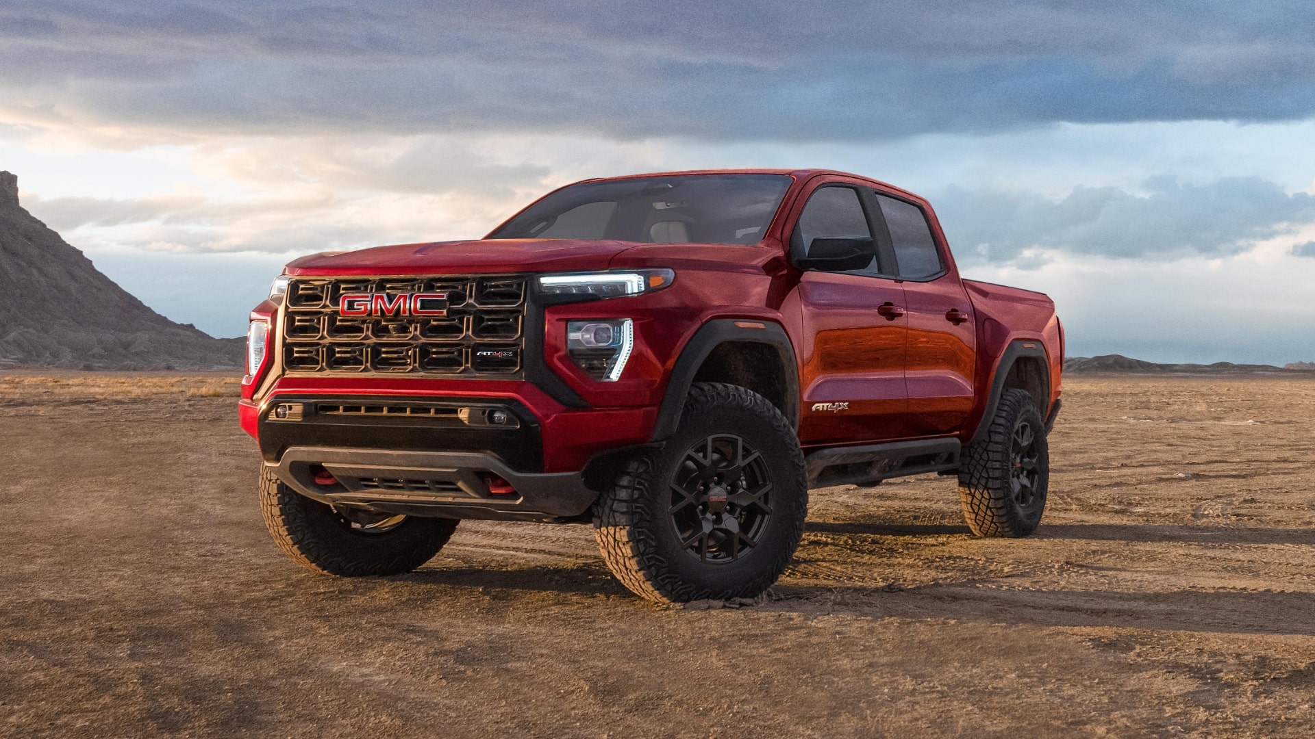 A Red 2027 GMC Canyon AT4X Truck Parked on a Dirt Road in a Desert Landscape