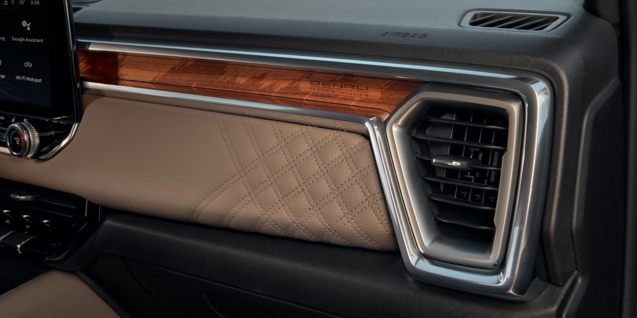 The Passenger Side Dashboard of a 2027 GMC Canyon with Wood Trim and Quilted Tan Upholstery
