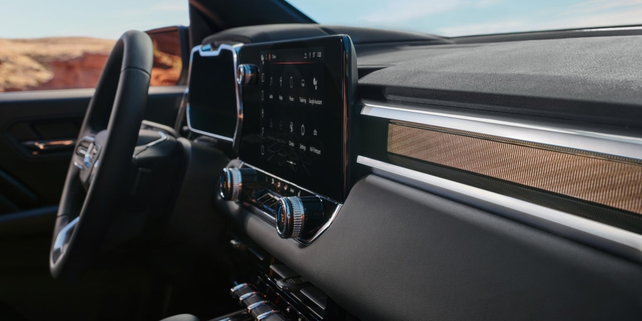 The Dashboard and Infotainment Screen of a 2027 GMC Canyon with Wood Grain Trim